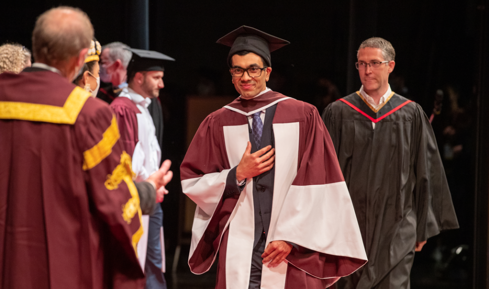 A Faculty of Health Science graduate crosses the stage at convocation