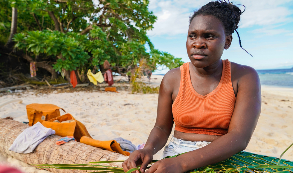 Maryanne Oketch sitting on a beach in Fiji