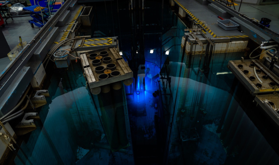 The core of McMaster's Nuclear Reactor giving off a blue glow inside of a pool.