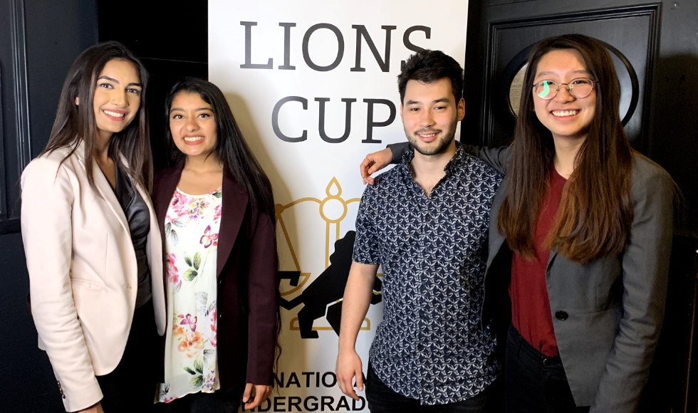 Lesha Shah, Navya Sheth, Lawrence Eikenboom and Jennifer Zhu posing for a photo while standing in front of a banner that reads ‘Lions Cup.’