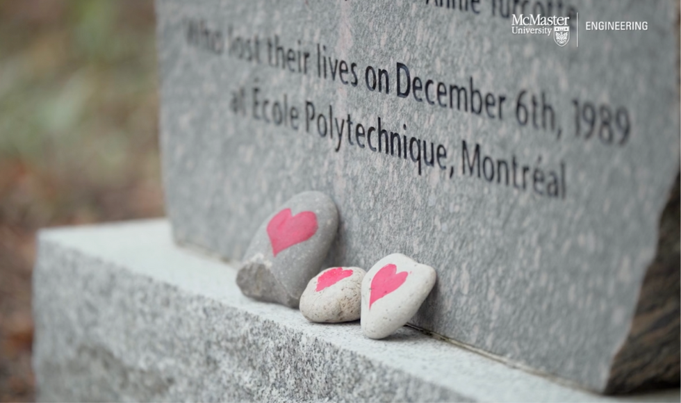 Three rocks with hearts painted on them lean against the stone memorial commemorating the victims of the 1989 Montreal Massacre outside the Faculty of Engineering