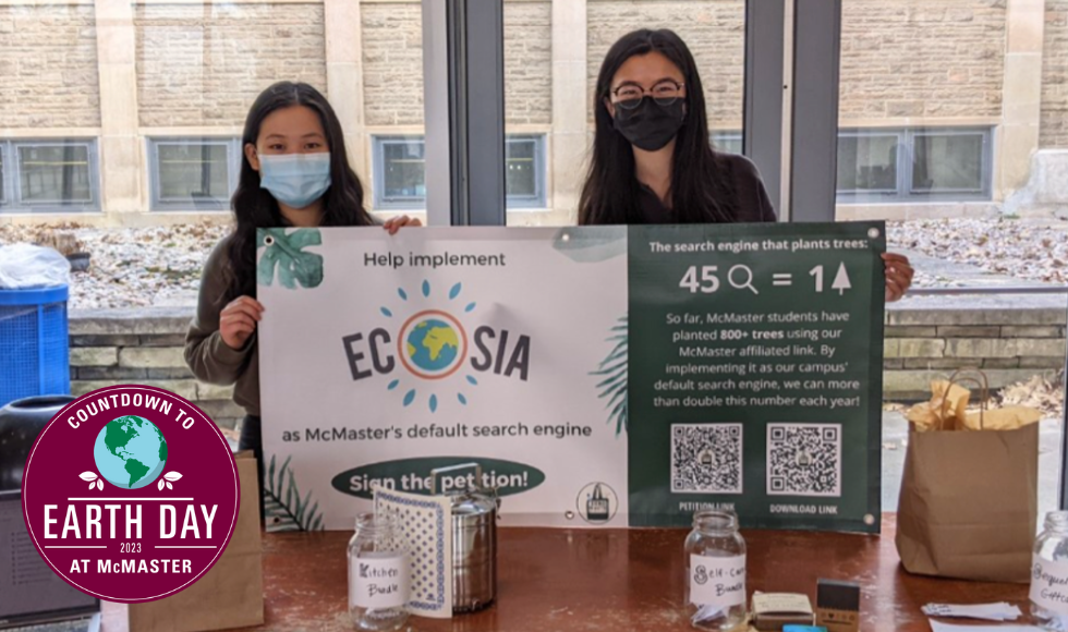 Two McMaster students holding up a sign advertising the Ecosia browser