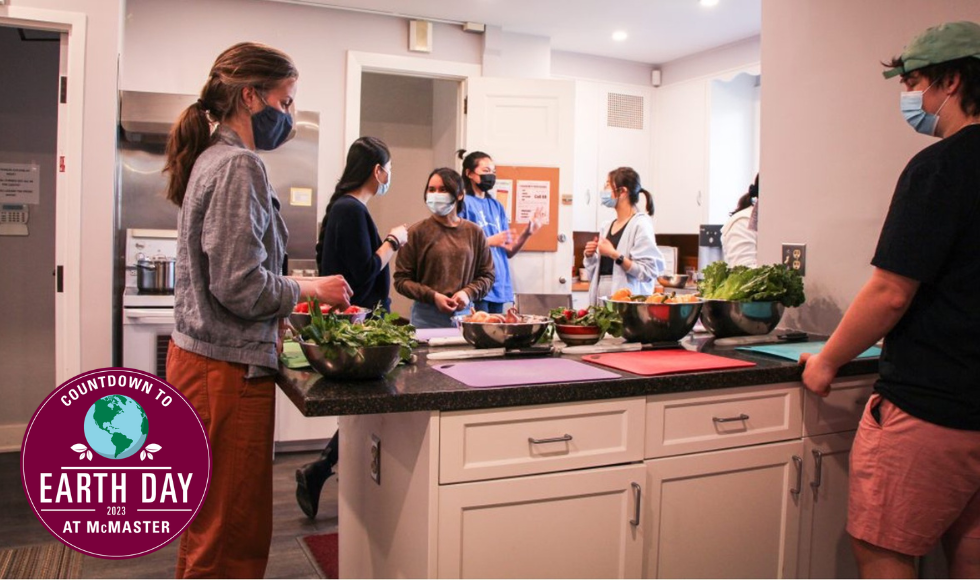 Seven people wearing masks preparing food in a kitchen