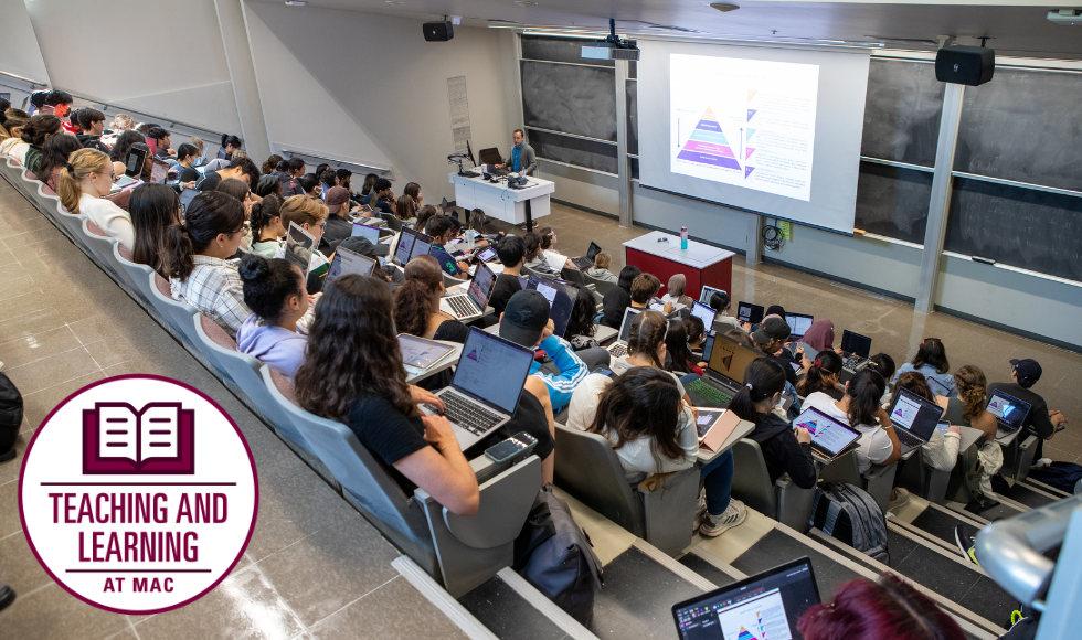 Students sitting in a lecture hall while a professor teaches