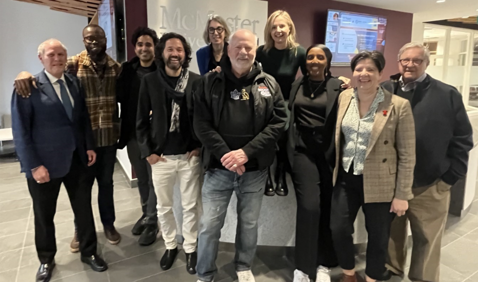 A group of 12 people, including Peter Mansbridge, McMaster president David Farrar and Dean of Humanities Pamela Swett.