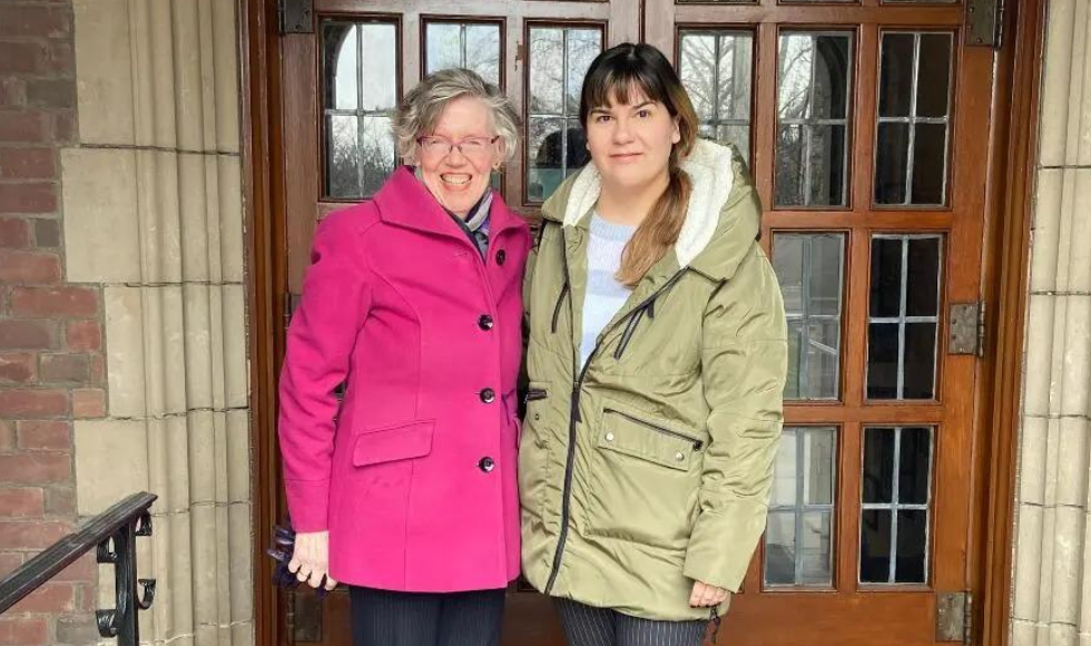 Lynda Davey-Longstreet and Emily Gula standing in front of ornate doors.