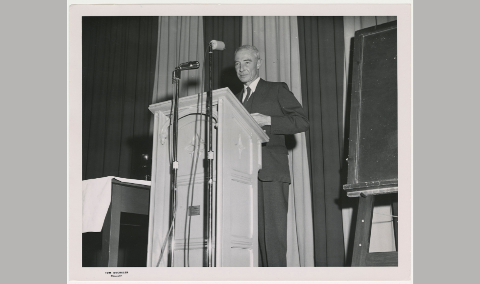 A man in a suit speaking at a podium
