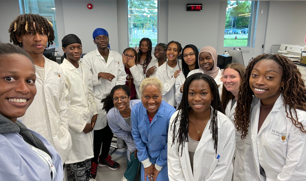 A group of people in lab coats smiling at the camera