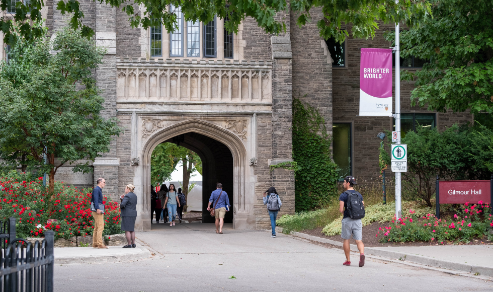 McMaster community members walking through the University Hall archway
