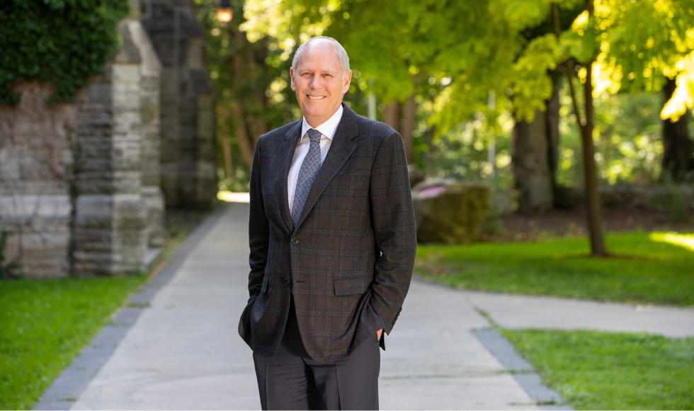 David Farrar in a suit, standing outdoors in the shade on a sunny day at McMaster