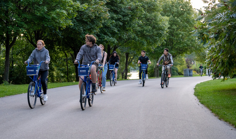 A group of students cycling along a paved trail