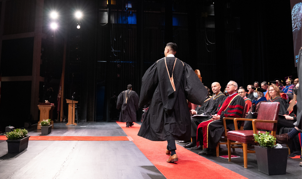 A graduate crosses the stage at a Fall 2022 convocation ceremony (Photo by Matt Clarke/McMaster University).