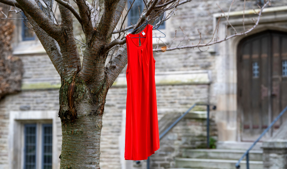 A red dress hanging from a tree outside University Hall.