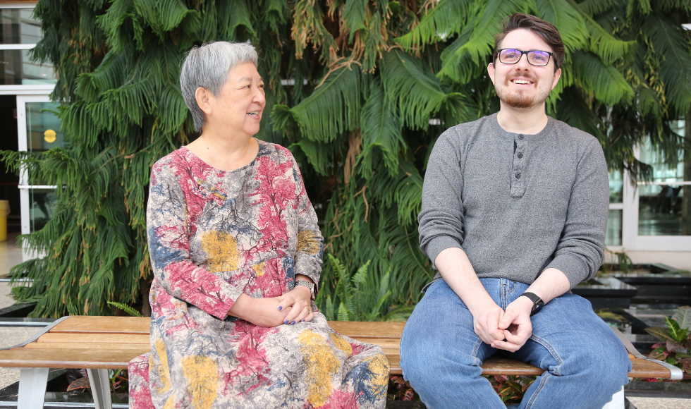 Image of Pat Chow-Fraser and Tyler Charlebois’ sitting on a bench laughing