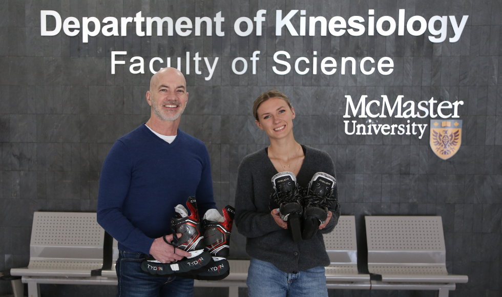 Image of Kinesiology Professor Martin Gibala on the left and graduate student Kaylee White on the right, holding their hockey skates and smiling for a photo