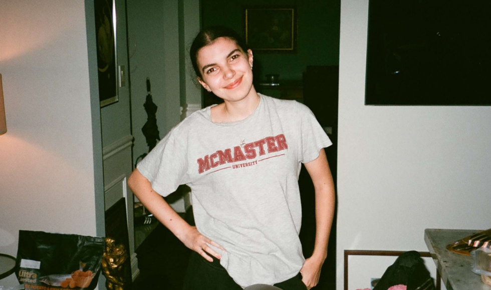 Emma Resendes smiling at the camera while wearing a McMaster t-shirt