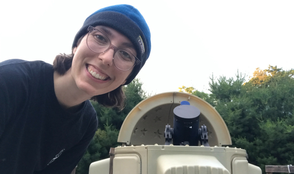 Veronika Dornan, smiling in the foreground, with the dome telescope of Killarney Provincial Park in the background.