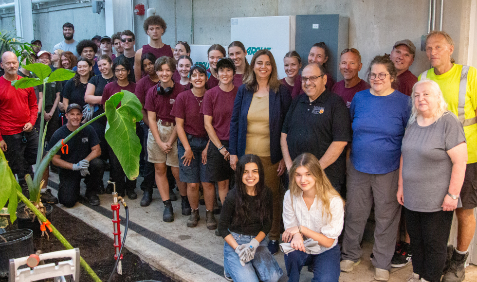 A group photo of a few dozen people who helped carry plants to the new greenhouse.