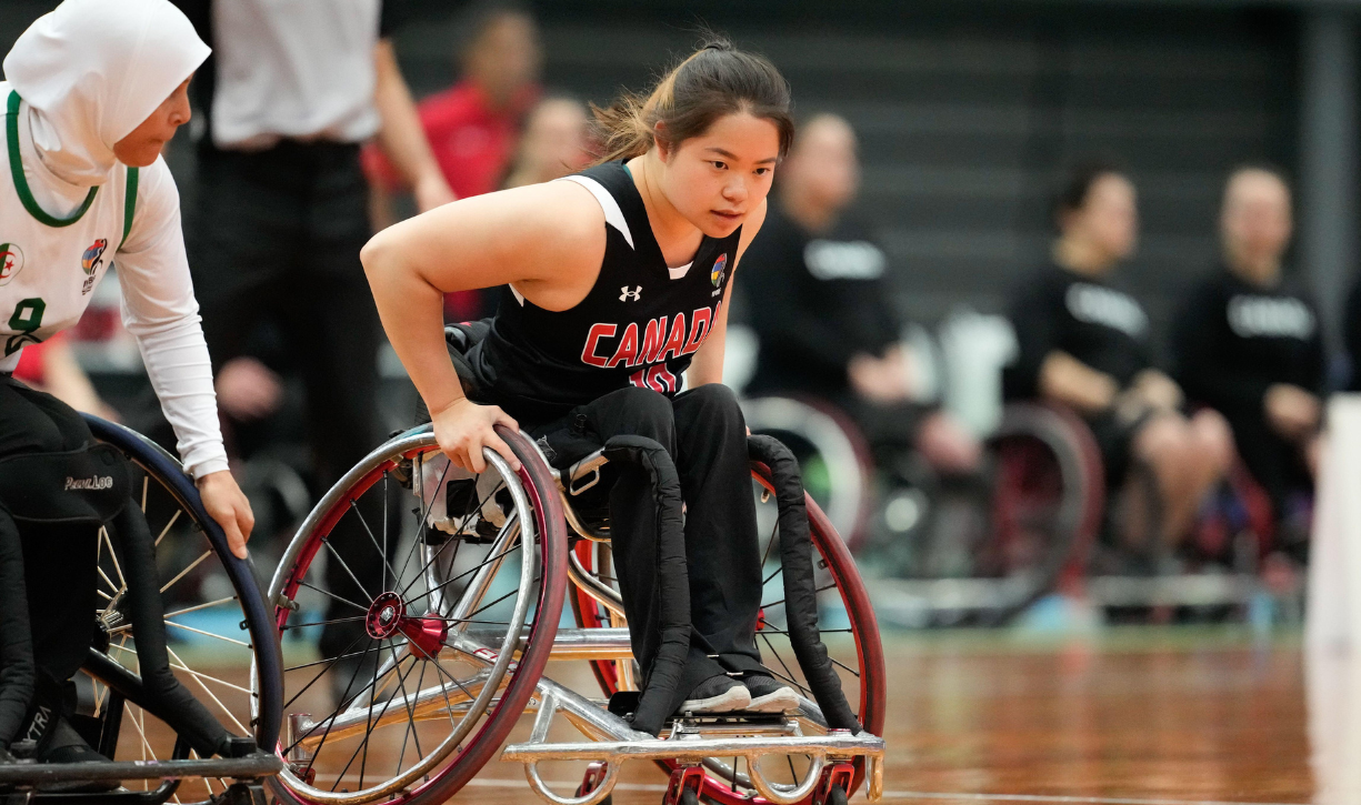 Puisand Lai and a competitor playing wheelchair basketball