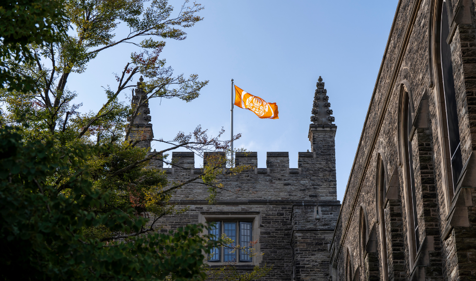 An orange flag flying on top of University Hall on McMaster's campus