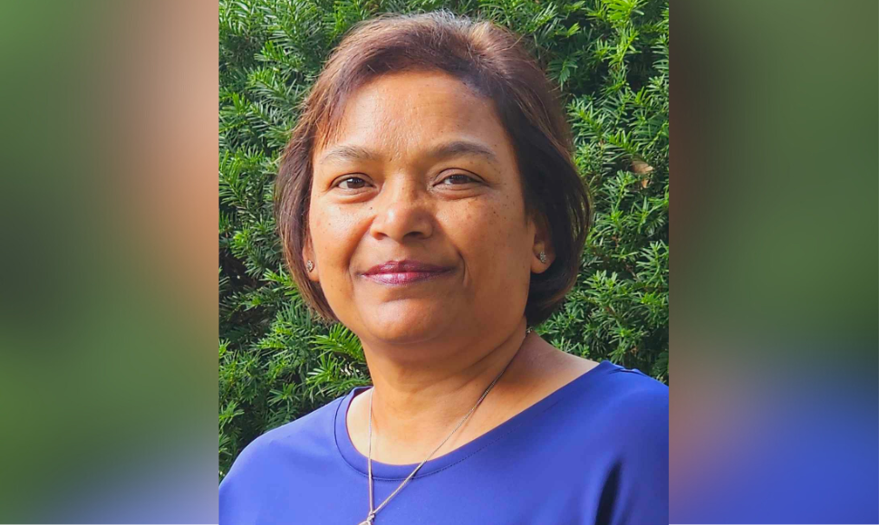 A headshot of Cheryl Louzado against a backdrop of greenery