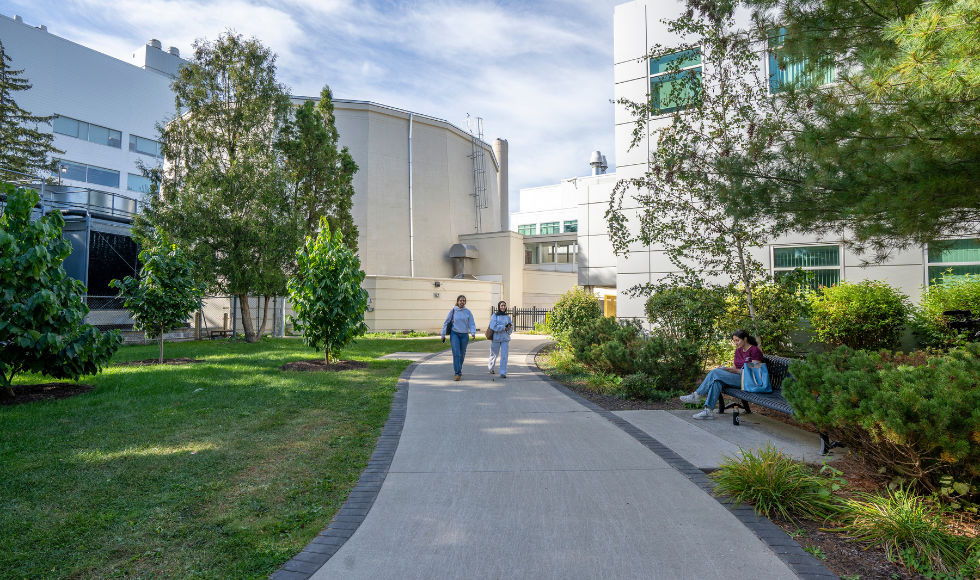 A view of the exterior of the McMaster Nuclear Reactor with several students in the foreground of the photo.