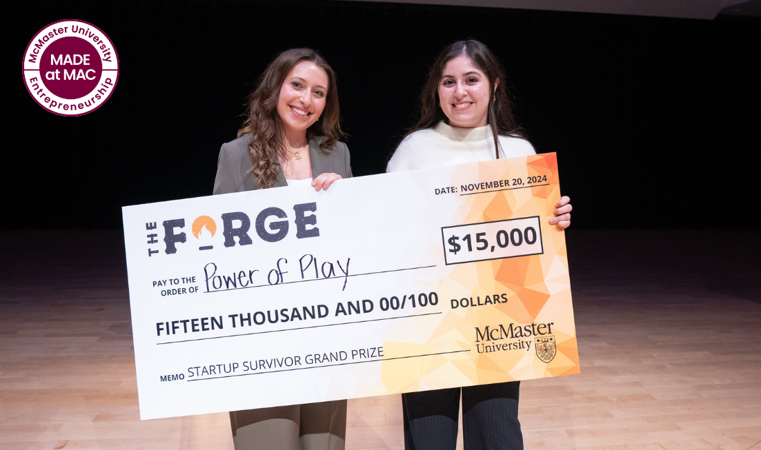 Two smiling people hold an oversized cheque for the Forge's Startup Survivor $15,000 Grand Prize in front of them.