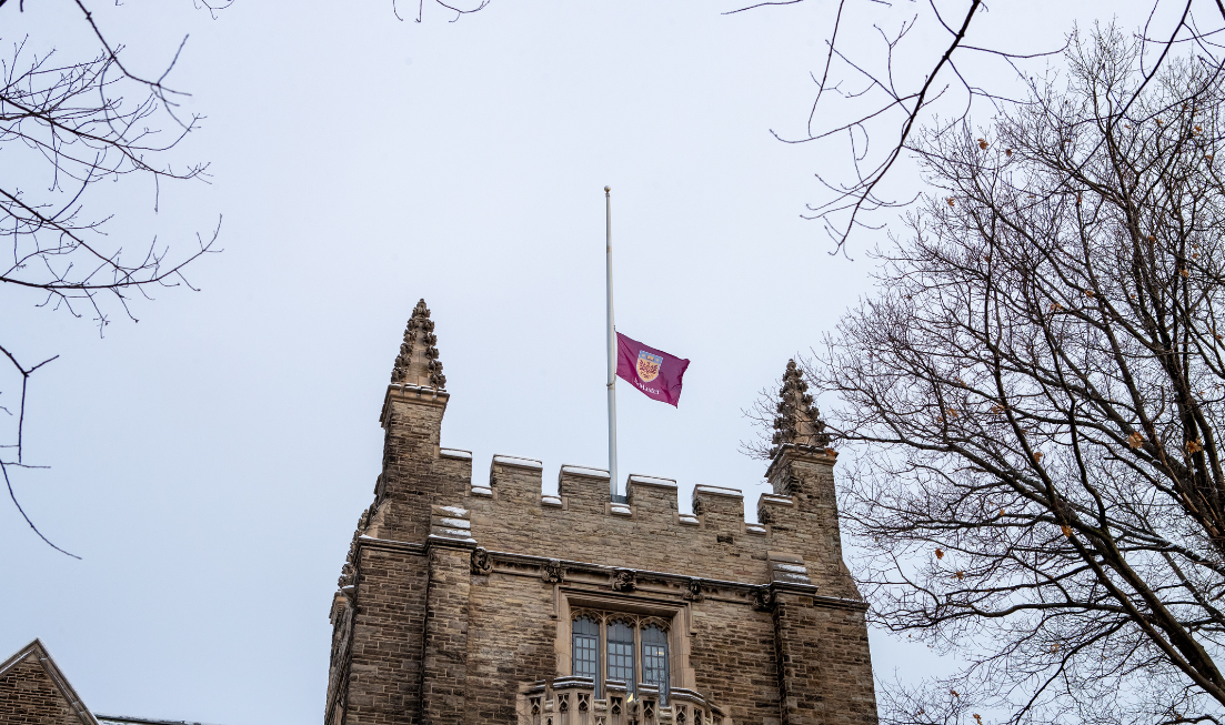 McMaster's purple flag flies at half-mast at the top of University Hall's tower in the winter time.