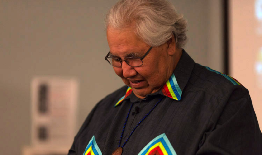 A closeup of Murray Sinclair with his head bowed or looking downward, wearing a black shirt.