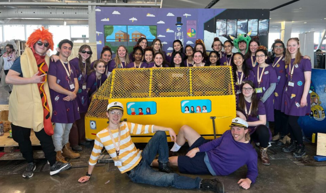 Group picture of McMaster's 2025 Concrete Toboggan team, taken indoors, in zany costumes.