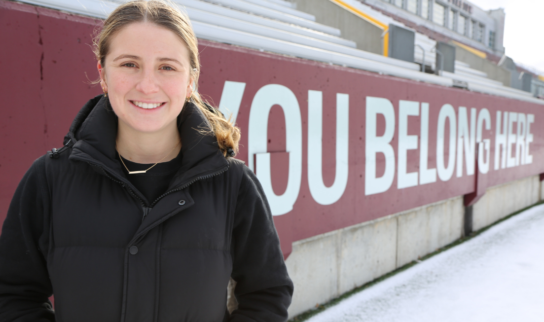 Olivia Beausoleil in the foreground in front of the stadium wall with 