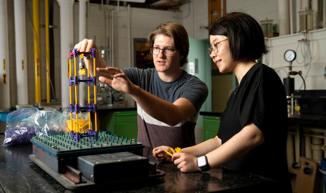 Two students work on a 3-dimensional model in the engineering building at McMaster.