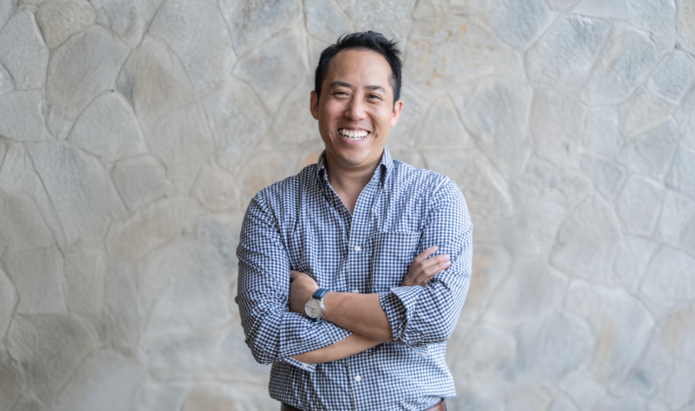 Waist-up image of smiling Shawn Cheung, wearing a blue checkered shirt against a neutral backdrop