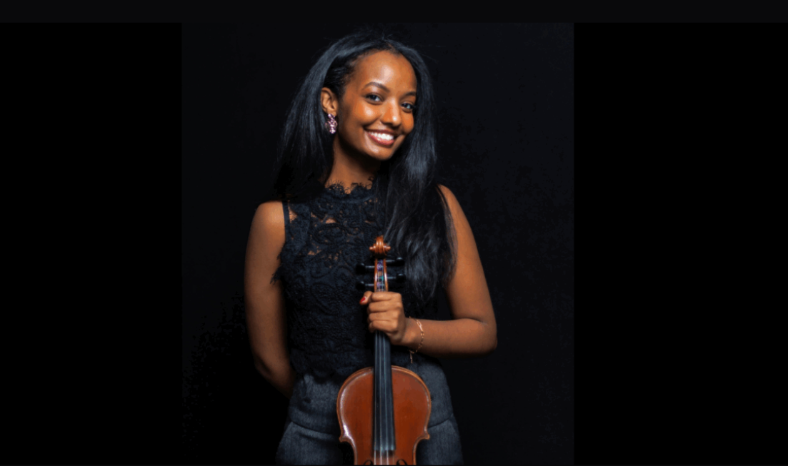 Alador Bereketab holds her violin and smiles