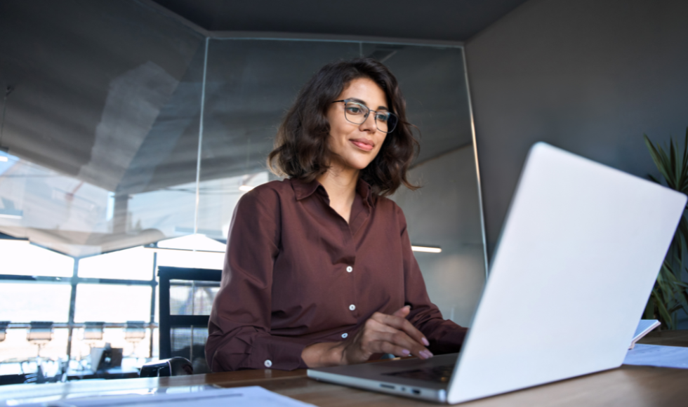 A woman sits at a laptop.
