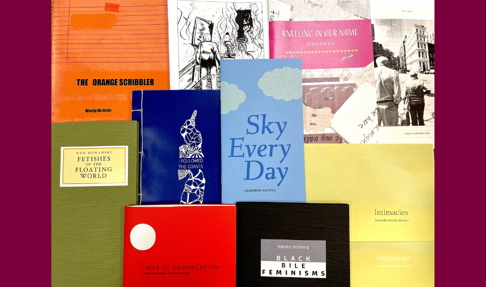 Various chapbooks with different coloured covers lay on top of one another.