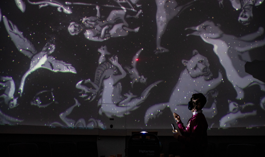 Silhouette of a person conducting a show about constellations in the planetarium on campus.