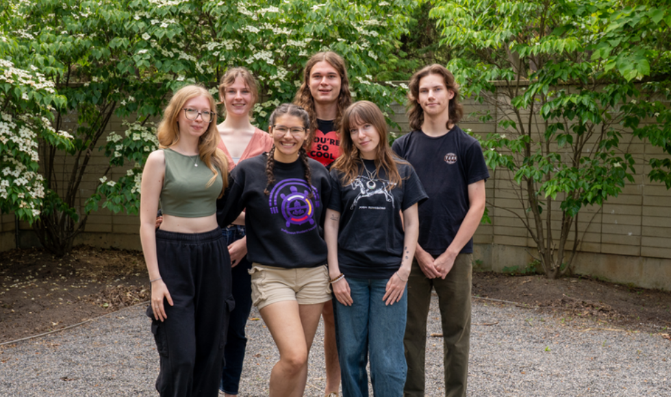 A group shot of seven people standing outside.
