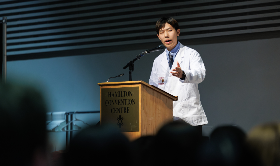  Donny Li delivers a speech at a podium.
