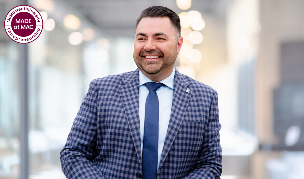 The Made at Mac mark in the corner of a picture of Tej Sandhu, wearing a suit and tie, smiling as he looks to the side of the camera.