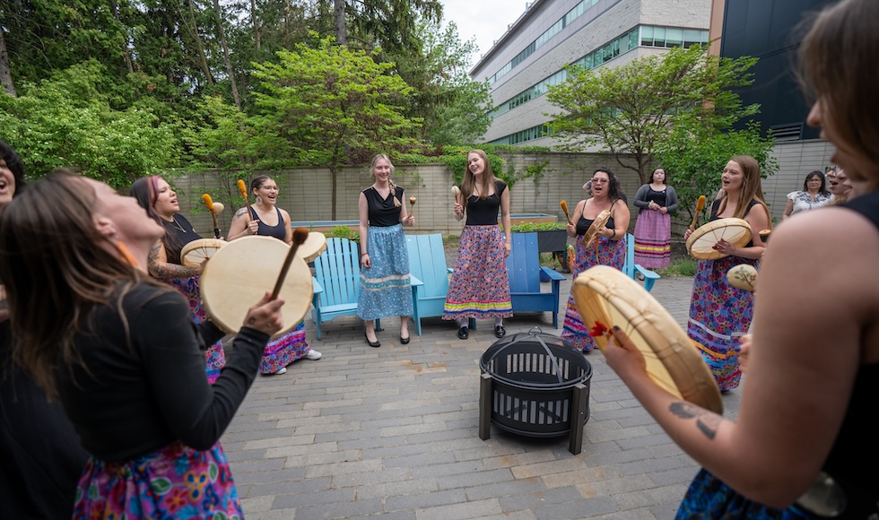 People stand in a drum circle.